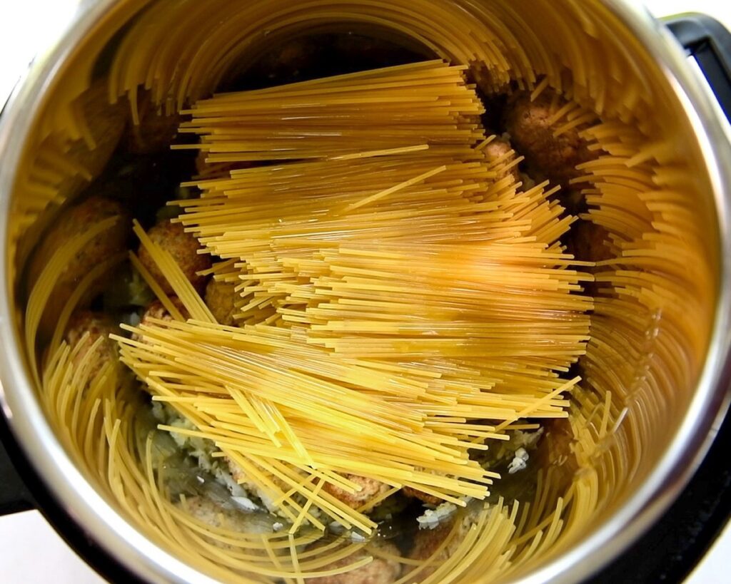 Uncooked spaghetti pasta is placed in the instant pot.