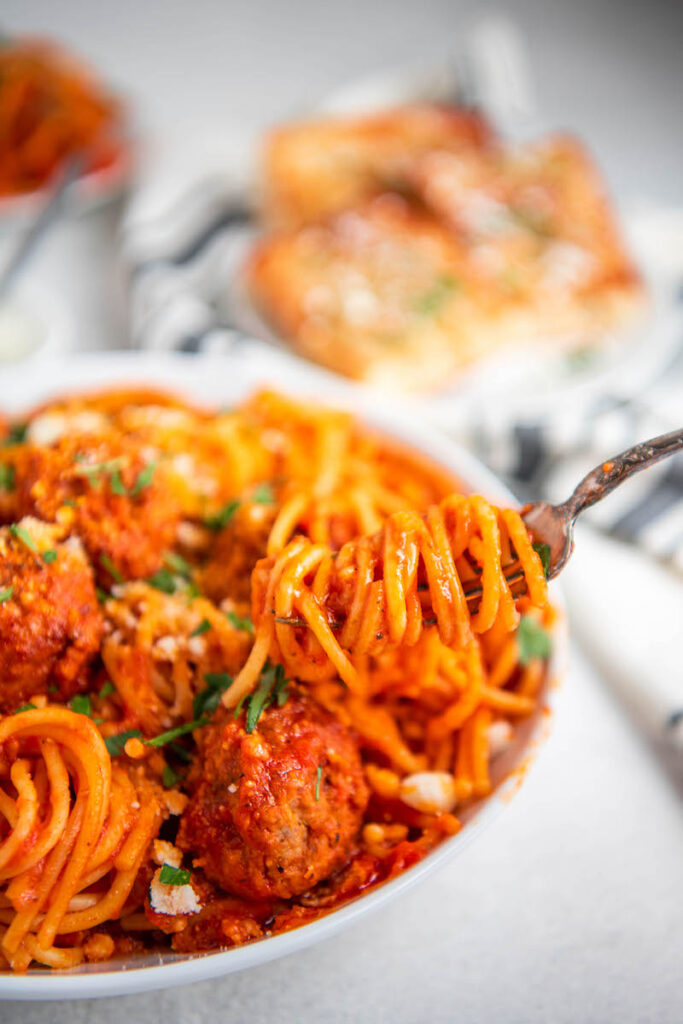 Up close image of spaghetti being twirled on a fork.