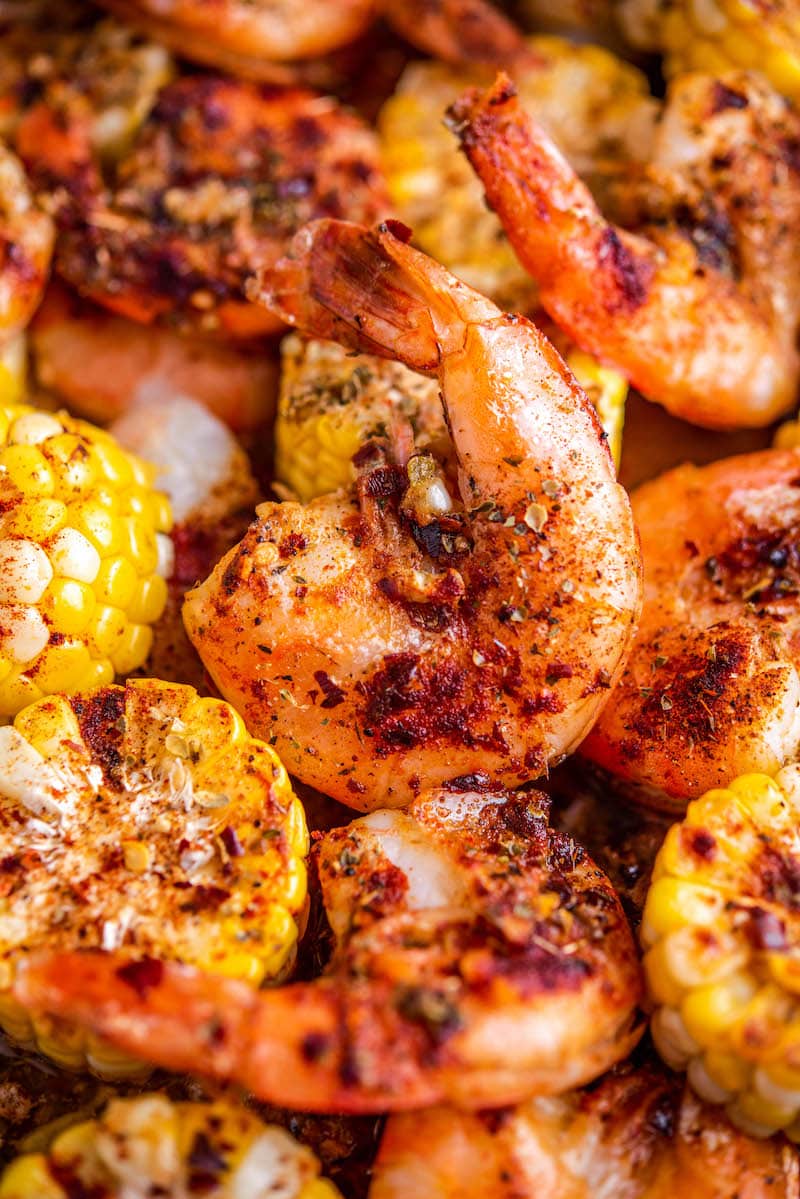 Cooked shrimp and corn on a roasting pan.