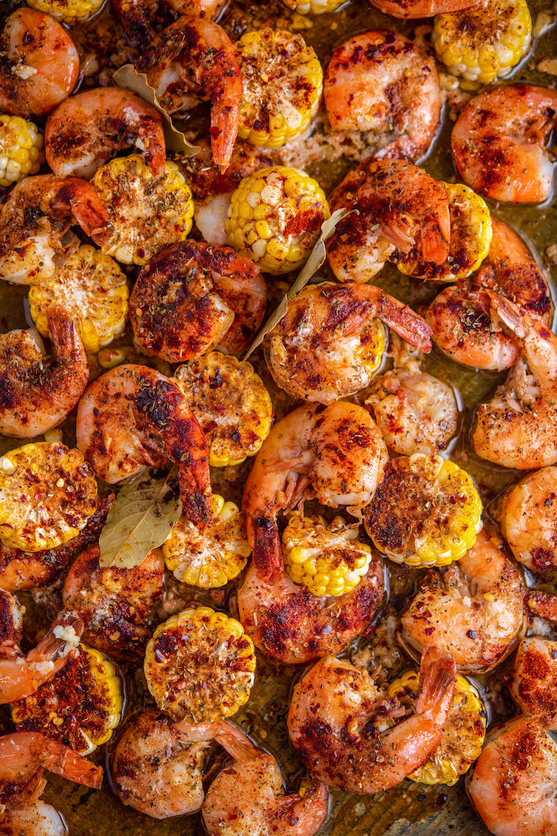 Cooked shrimp with corn in a roasting pan.