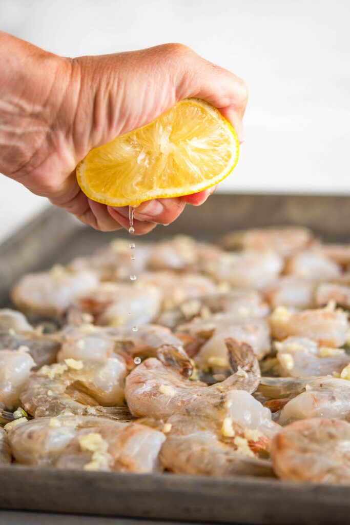 Sheet pan with raw shrimp, garlic and fresh squeezed lemon