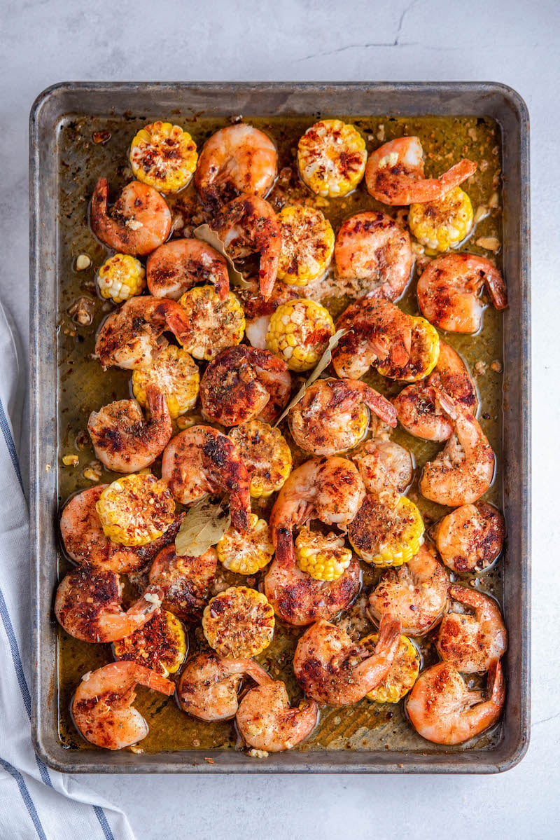 Cooked shrimp with corn on a roasting pan.