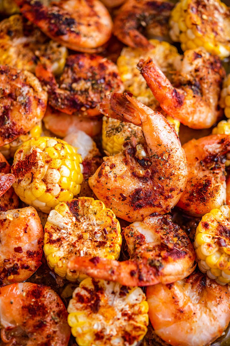 Garlic Butter Shrimp with corn and seasonings on a sheet pan.