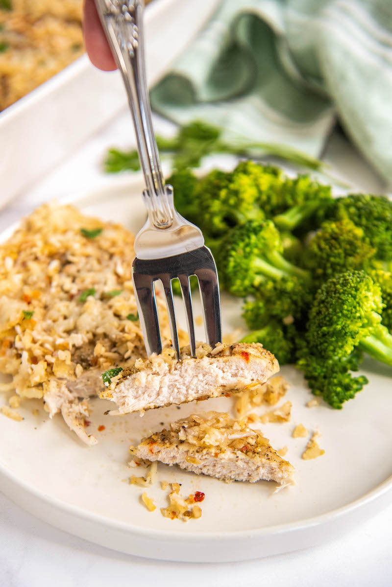 Yum Yum Chicken on a white plate with a fork holding a piece of cut chicken.