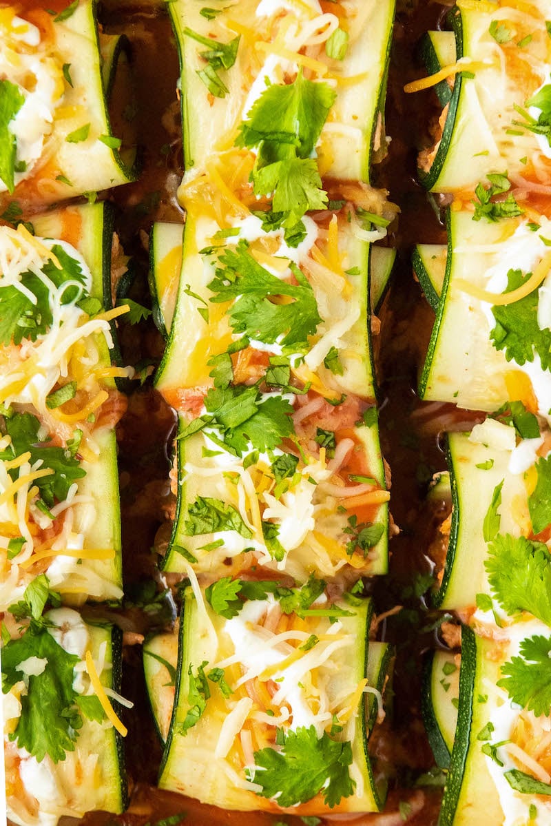 Zucchini enchiladas with cilantro and sour cream on top.
