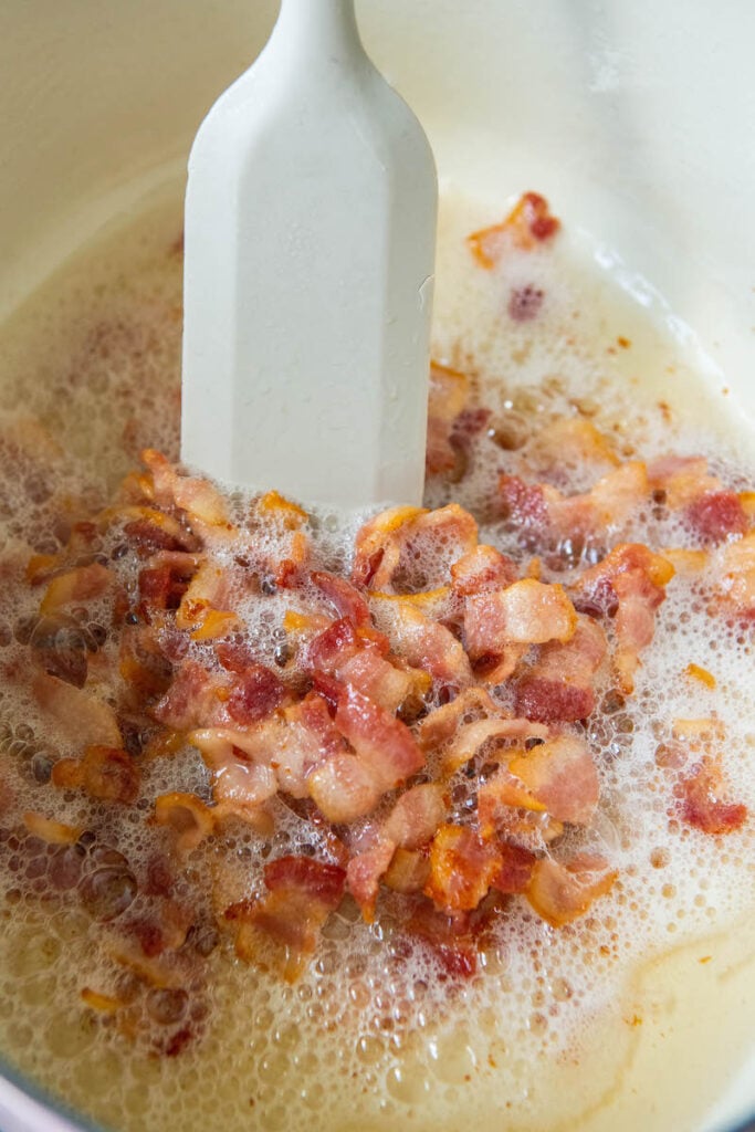 Bacon is being fried in a skillet