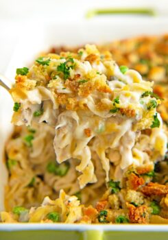 A hearty portion of tuna casserole is lifted from the baking dish.