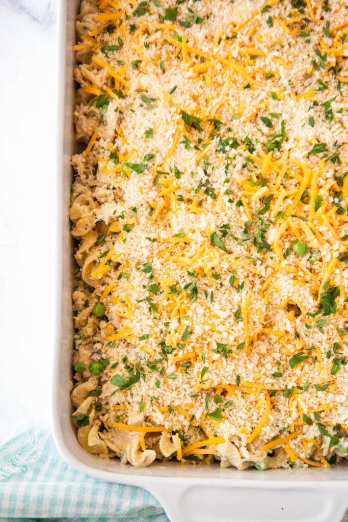 A baked pan of tuna noodle casserole is placed on a white tabletop.