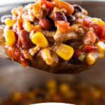 Up close image of taco soup on a spoon in an instant pot with wording on bottom for Pinterest