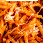 One pot penne pasta recipe in a pot with cheese on top with wording for pinterest.