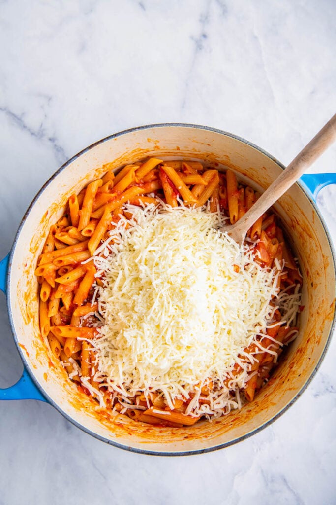 Cheese is poured on top of the cooked pasta