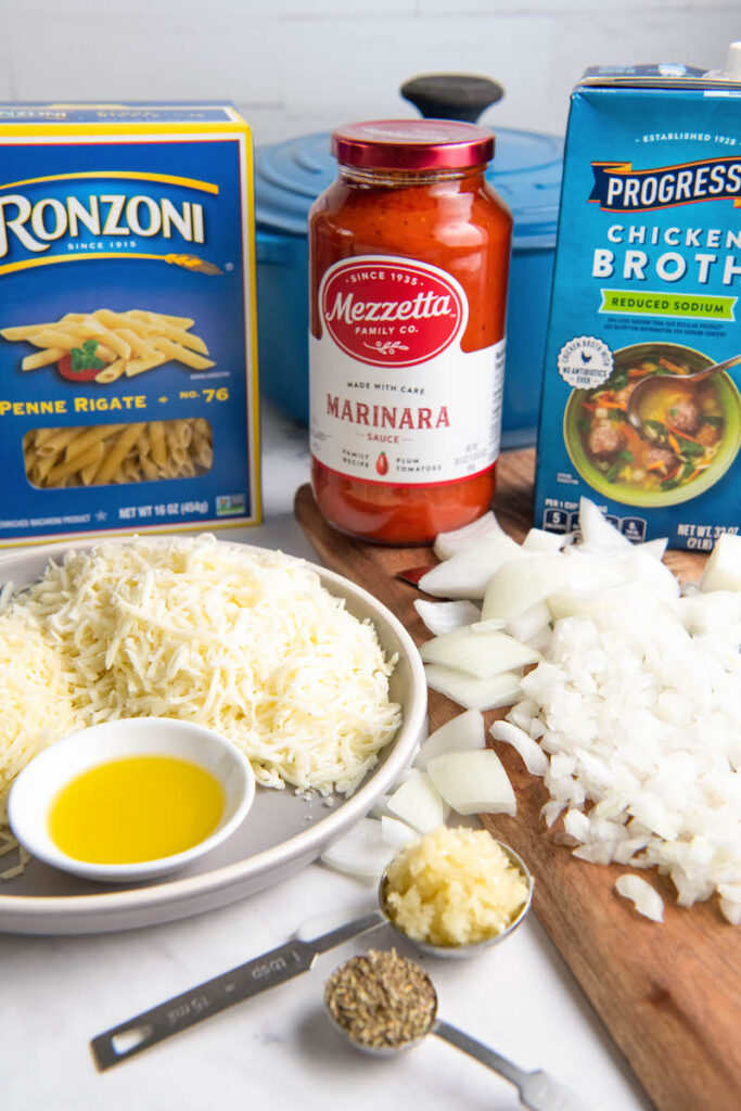 The ingredients for one pot pasta are placed on a white surface