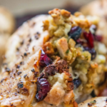 Pinterest image with wording on top and an up close image of stuffed chicken breast in a pan.