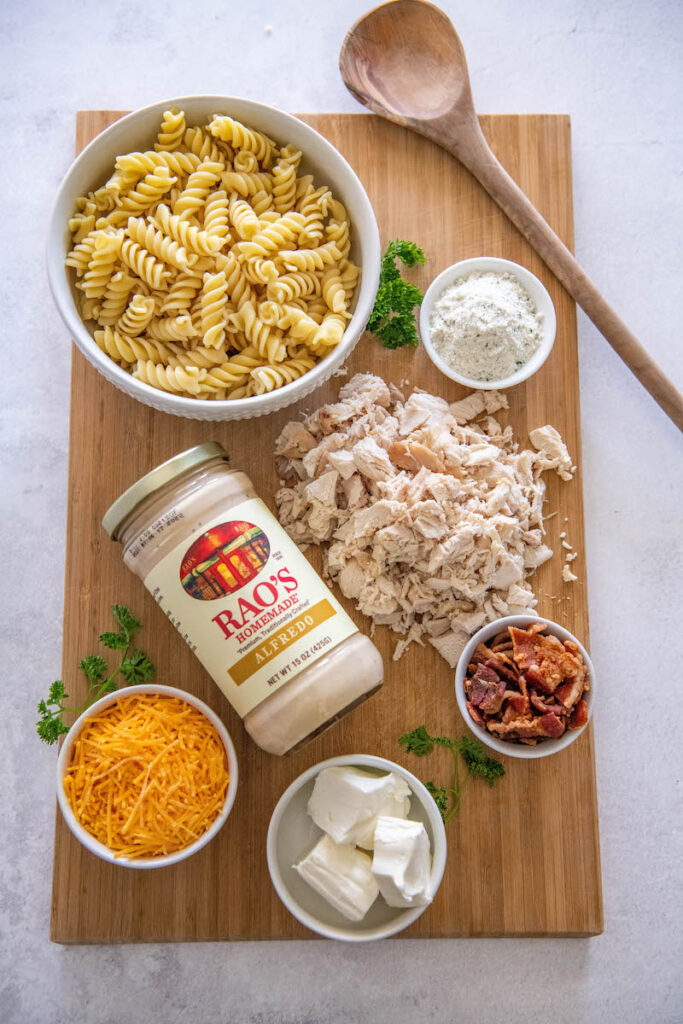 The ingredients for the dish are spread out on a wooden cutting board.