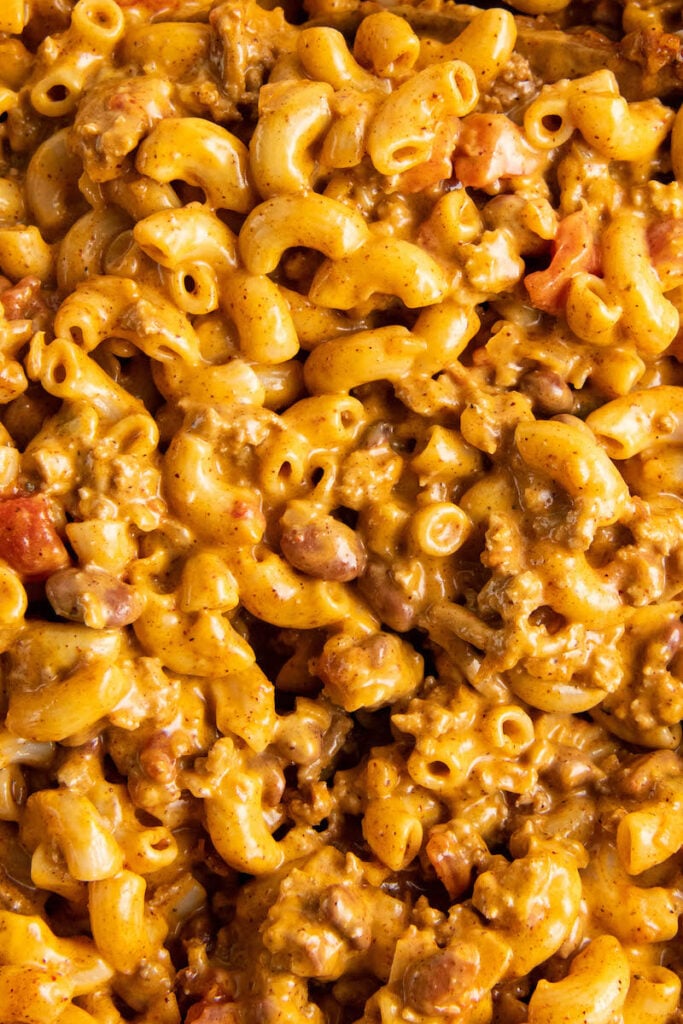 Elbow noodles are coated in yellow cheese mixed with brown ground beef.