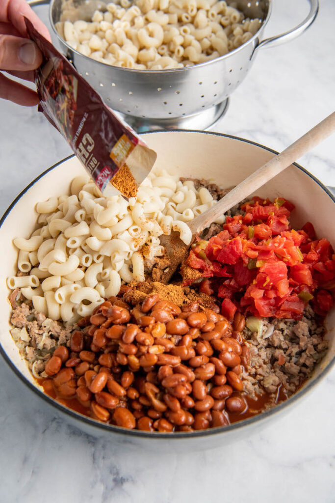 Beans, noodles, Rotel, ground meat and seasoning are mixed together in a large pot.