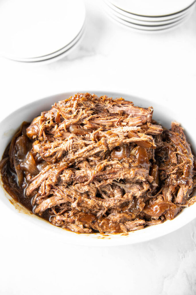 Shredded meat sits in a white bowl.