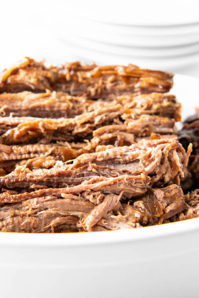 Shredded beef is in a white serving bowl.