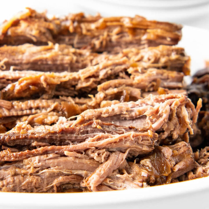 Shredded beef is in a white serving bowl.