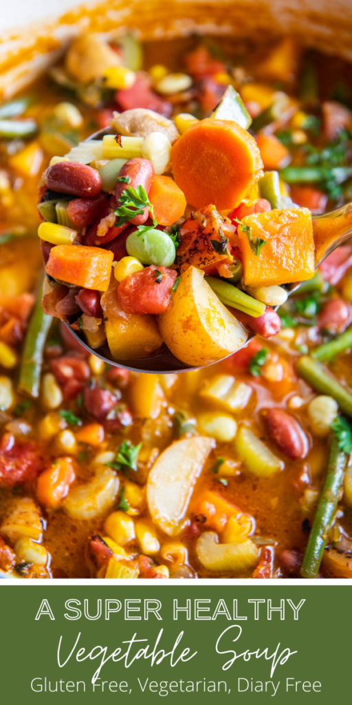 Up close image of vegetable soup in a pot with a spoonful being pulled out.