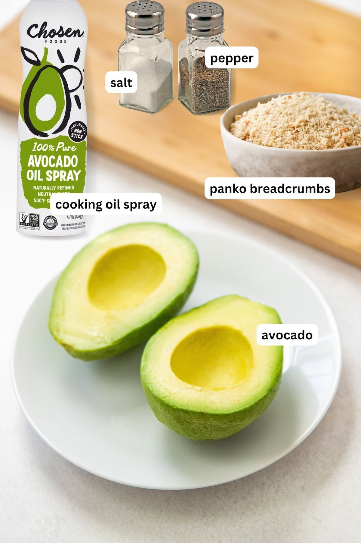 Ingredients for air fryer avocado recipe in order from top to bottom: salt, pepper, breadcrumbs, cooking oil spray, avocado.