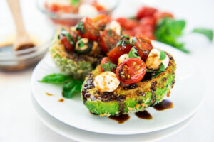 A plate with two pieces of caprese stuffed avocado