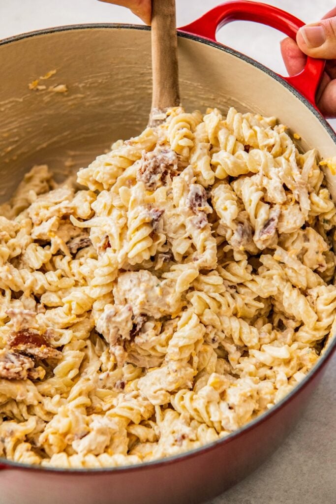 Chicken ranch pasta stirring in a large dutch oven.