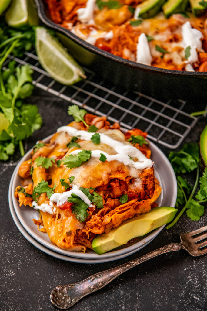 A plate full of chicken enchiladas is ready to be eaten.