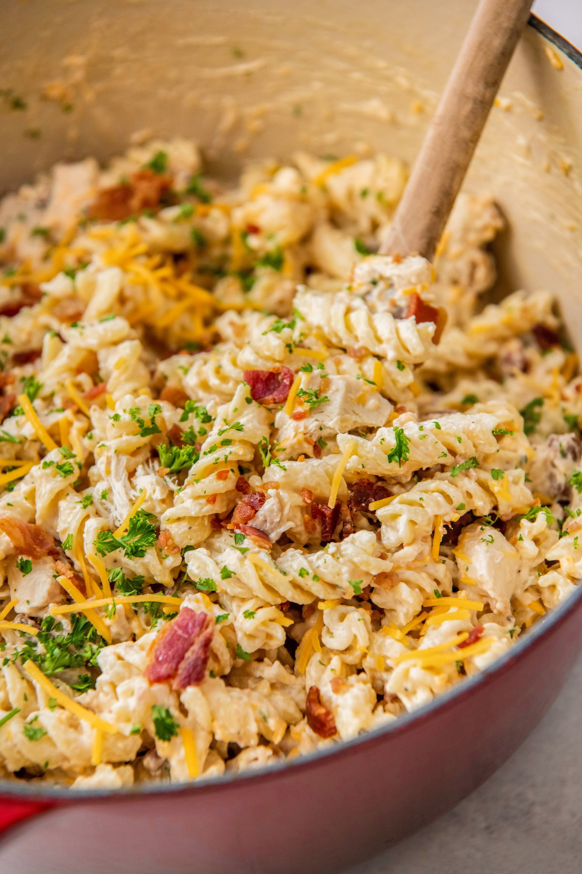 Chicken bacon pasta with ranch is being mixed in a pot.