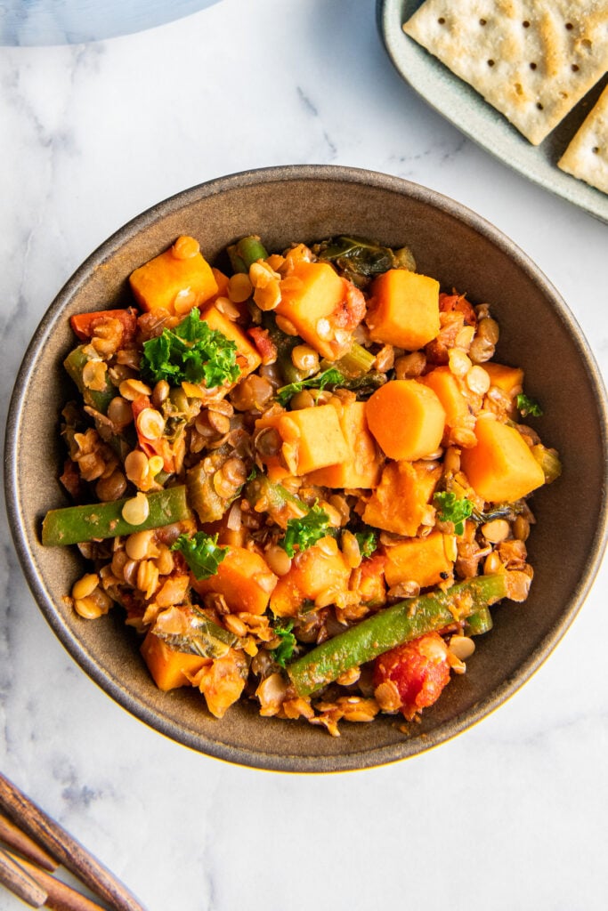 A small bowl contains a single serving of lentil stew. 