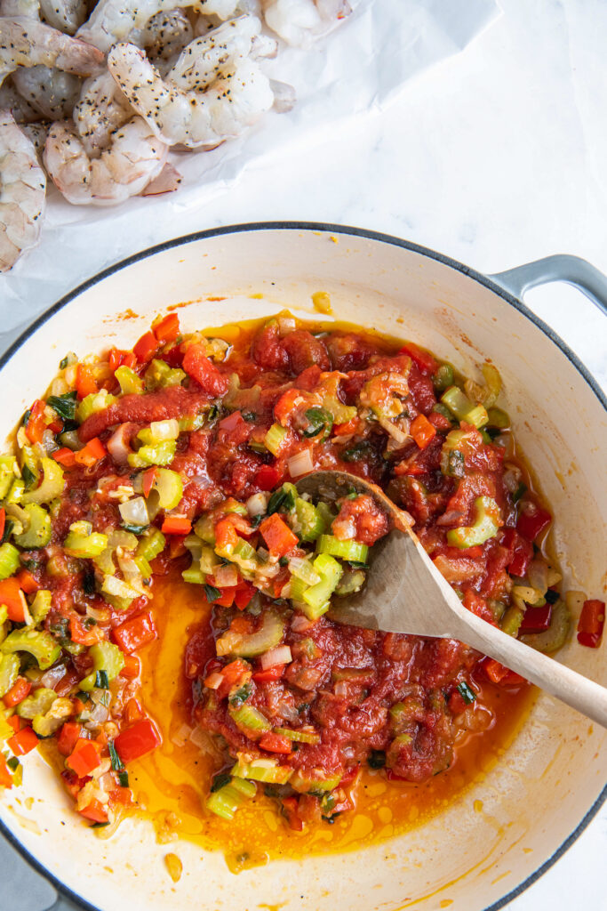 Skillet with tomato sauce and cooked chopped onions, celery, bell pepper