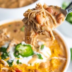 A bowl of chili and a spoon full of chicken chili