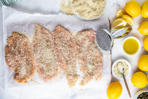 Raw chicken breast with breadcrumbs and lemons, olive oil and seasonings