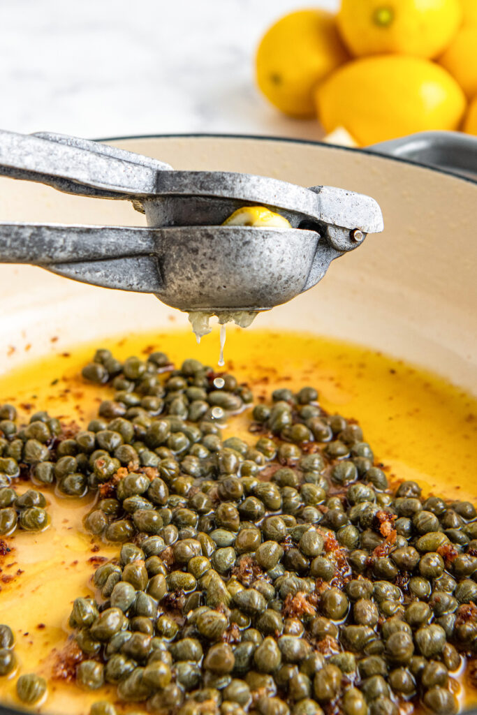 Lemon squeezed into pan with capers and oil