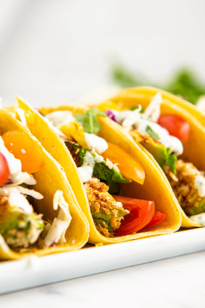 Tacos stuffed with air fried avocado slices and tomatoes