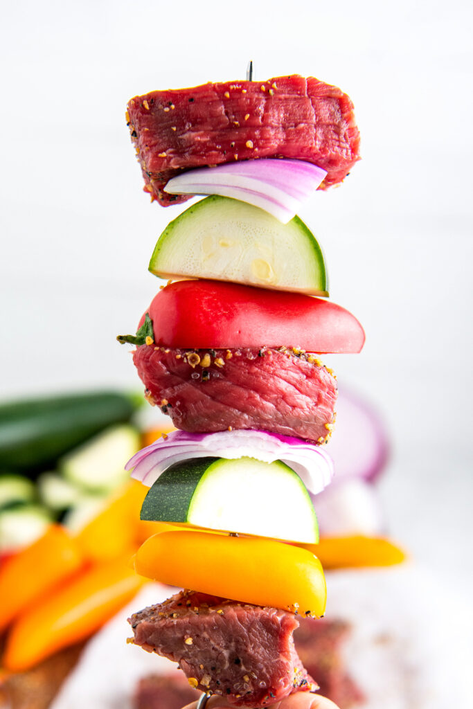 Shish kabob skewer with steak, zucchini, red onion and baby bell peppers