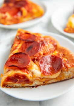 Pepperoni pizza slices on white plates