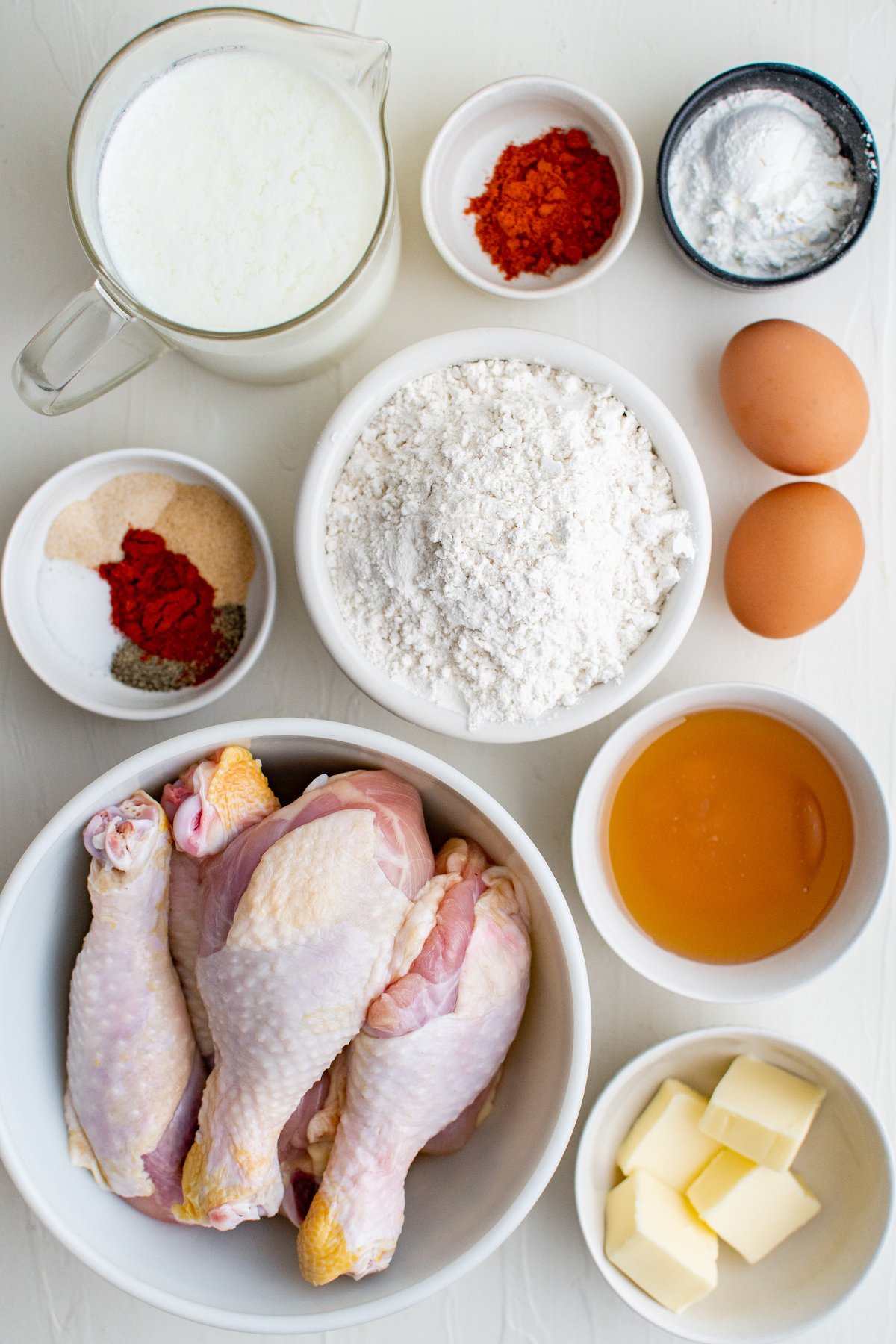 The ingredients for this chicken recipe are placed on a white surface. 