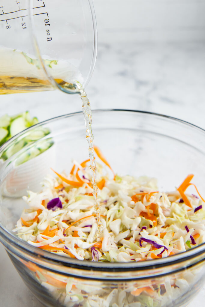 A bowl of slaw is in a glass bowl.