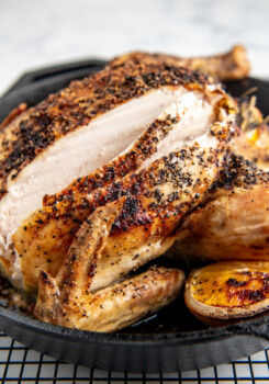 A roasted chicken has been sliced into, revealing cooked white meat.