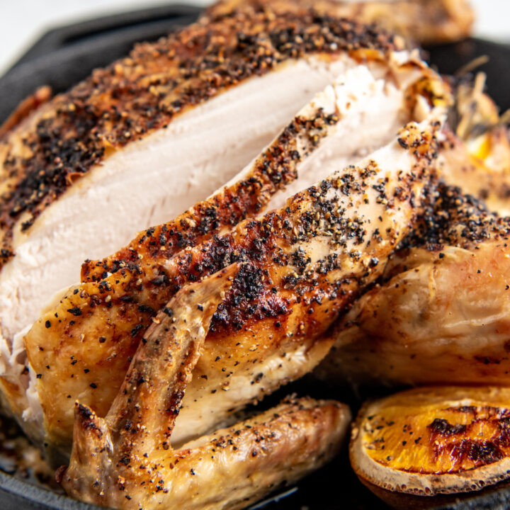 A roasted chicken has been sliced into, revealing cooked white meat.