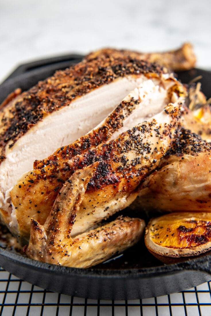 A roasted chicken has been sliced into, revealing cooked white meat.