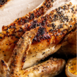 Up close image of roasted chicken being sliced into pieces.