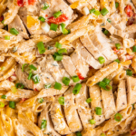 Up close image of Cajun Chicken Pasta with bell peppers and green onions sprinkled on top.