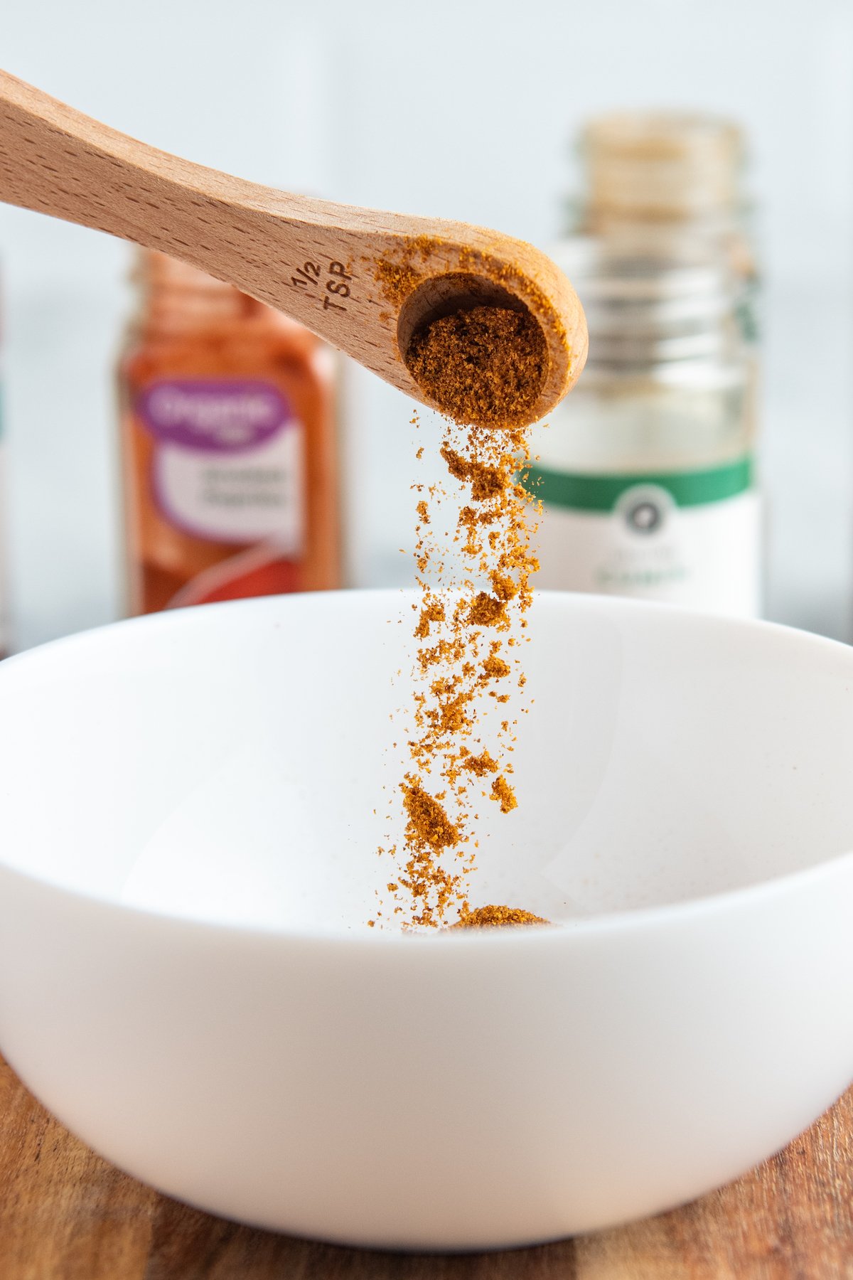 paprika being poured into a white bowl