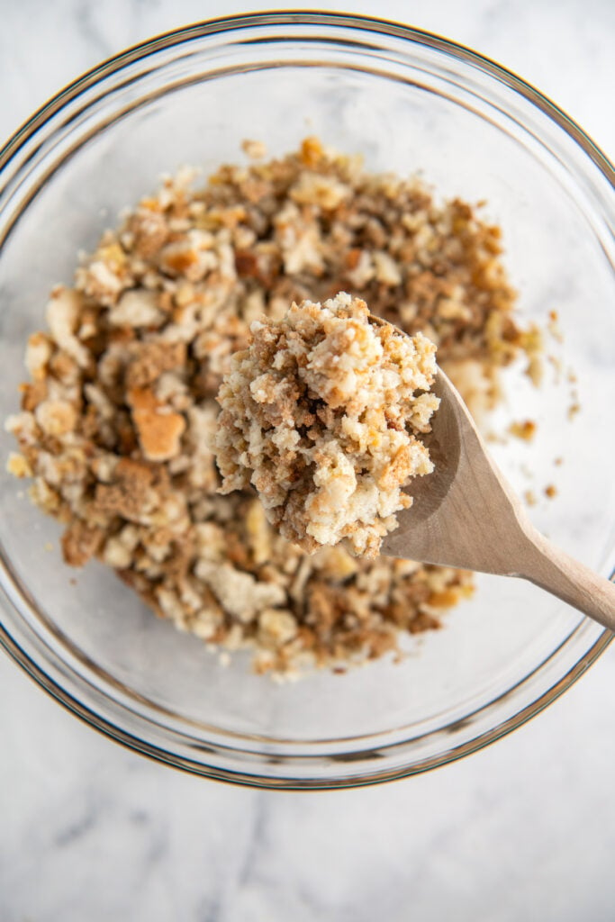 Stuffing mixture in a glass bowl with a wooden spoon.