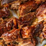 Up close image of country style ribs cut up on a white plate.