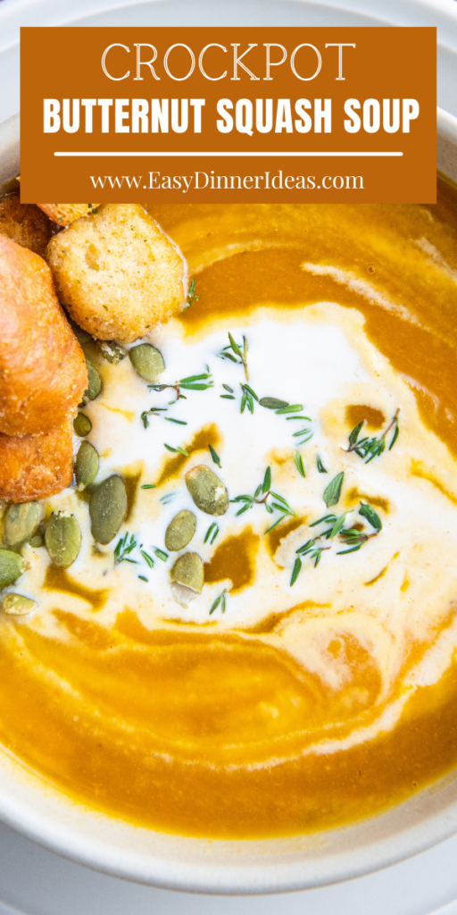 A bowl of butternut squash soup with cream on top and thyme.