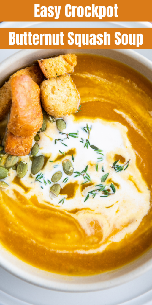 A bowl of butternut squash soup with cream on top.