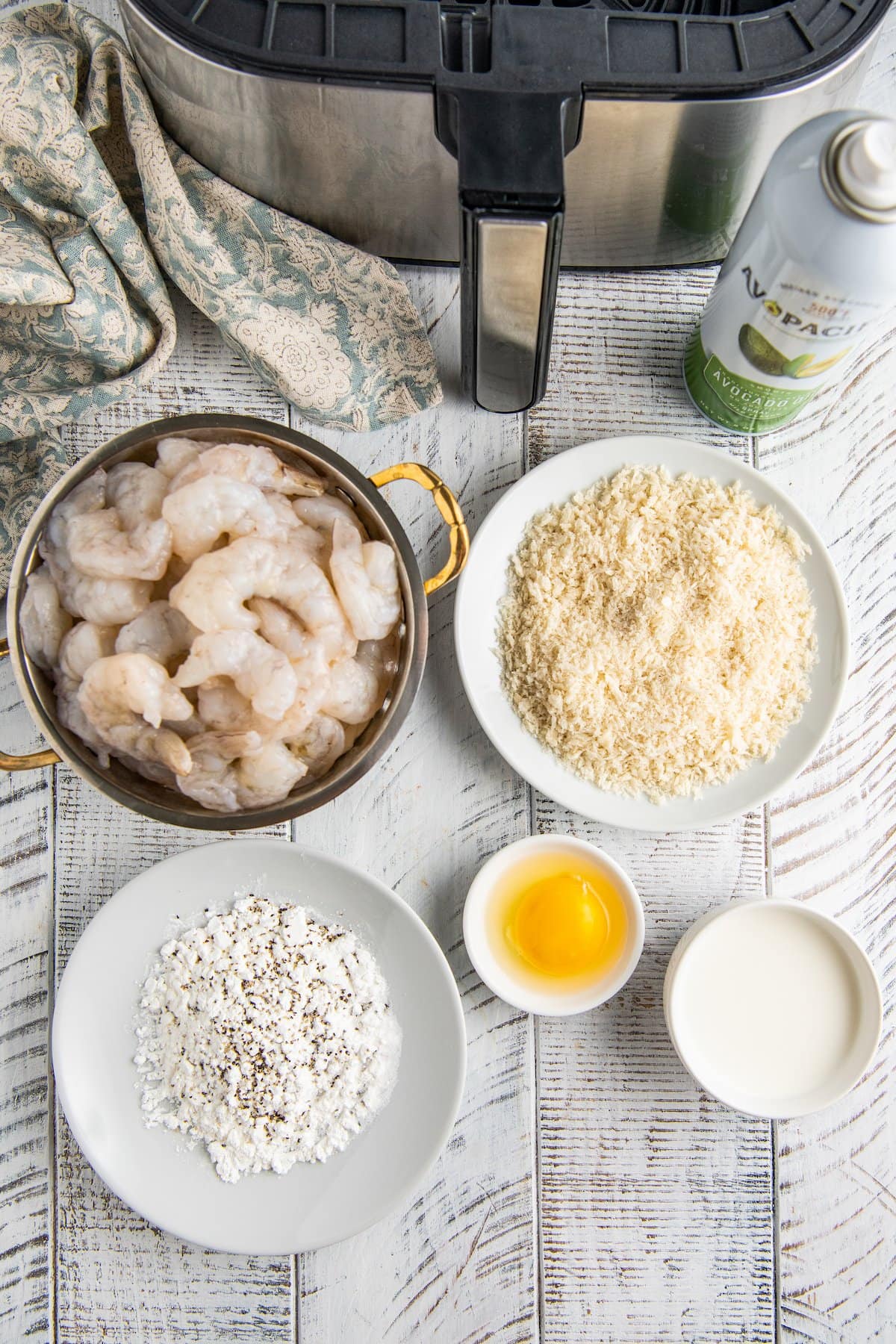 Ingredients for air fryer bang bang shrimp in white plates and bowls.